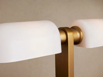 Zayd Table Lamp: Brass body with two rectangular opal glass shades, on a rustic wooden table against a neutral wall.