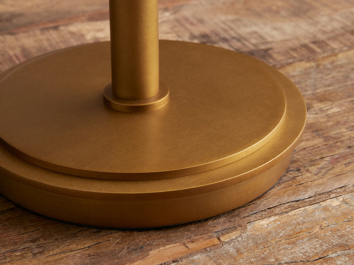 Zayd Swing Arm Table Lamp with a brass finish, white opal glass shade, on a rustic wooden table.