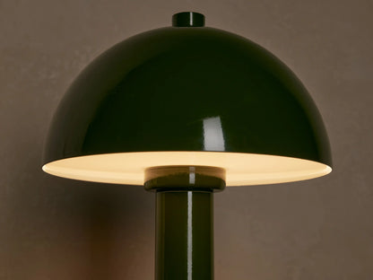 Green lacquered Jocy Portable Table Lamp with a mushroom-domed shade and cylindrical base on a wooden surface.