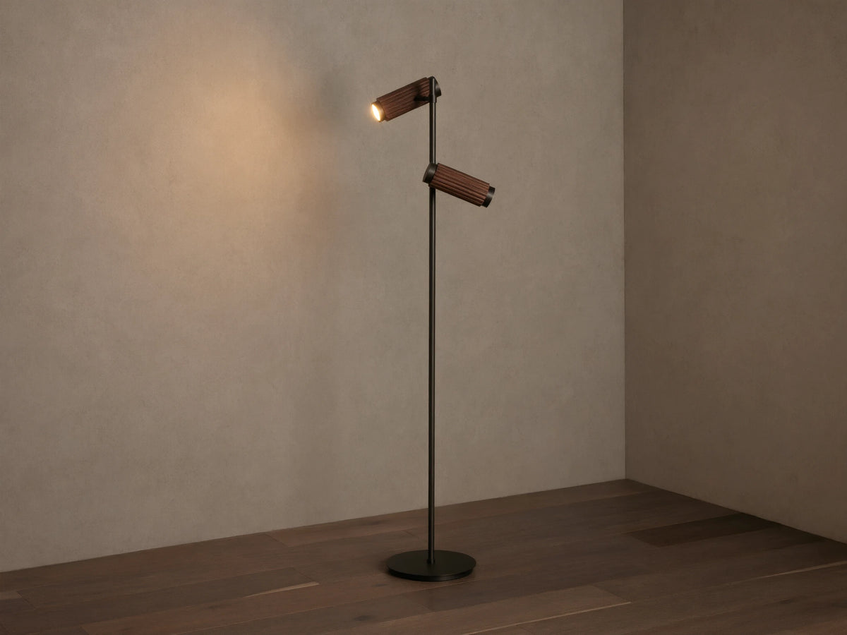 Decan Task Floor Lamp: bronze metal, two fluted walnut wood shades, one illuminated, casting a warm glow.