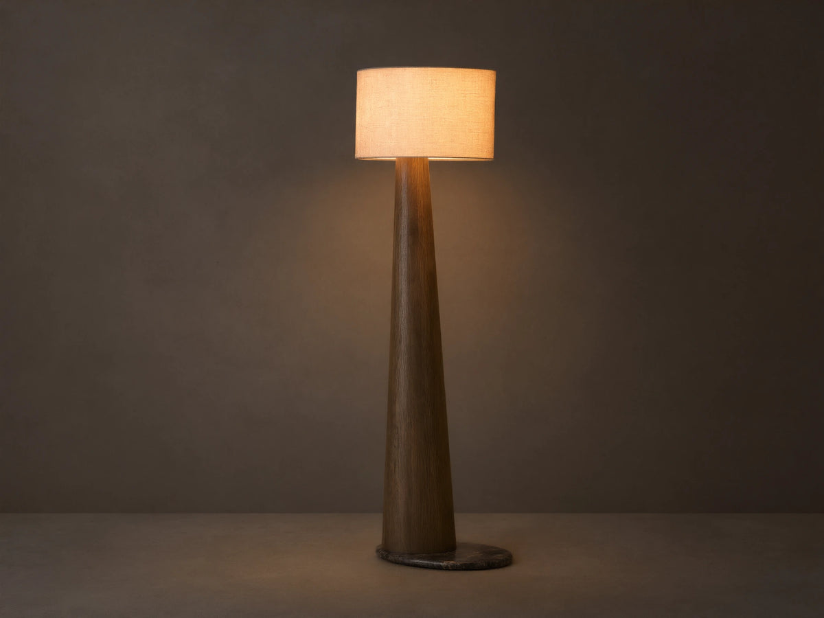 Front view of a tall floor lamp with a dark brown tapered wood base and a light beige rectangular fabric shade, emitting warm light.