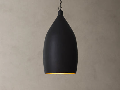A matte black pendant light with a smooth, teardrop shape hanging from a chain against a beige textured wall.