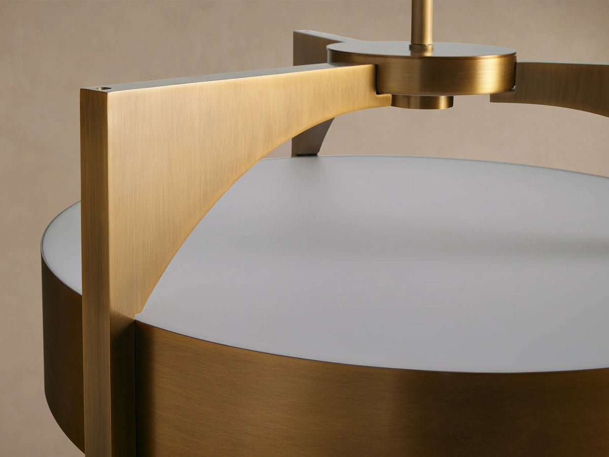 Alastair Pendant, close-up of its burnished brass cylindrical shade and perforated acrylic diffuser.