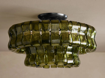 Ghiaccio Flush Mount, a tiered ceiling light made of wavy, dark green textured glass, illuminated with warm glow.