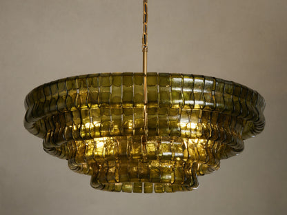 Ghiaccio Round Chandelier, dark green curved glass in tiered wavy layers, illuminated with warm golden light, hanging from chain.
