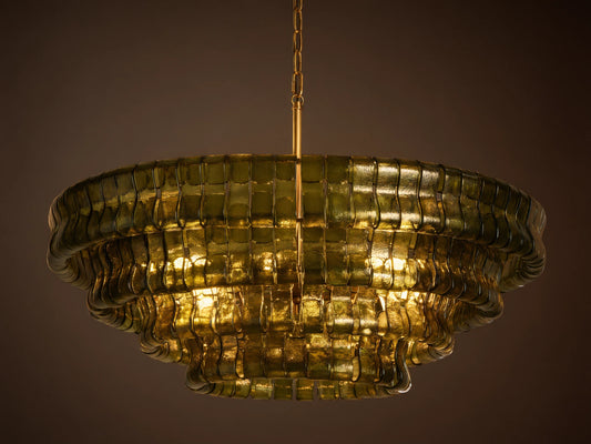 Ghiaccio Round Chandelier, dark green curved glass in tiered wavy layers, illuminated with warm golden light, hanging from chain.