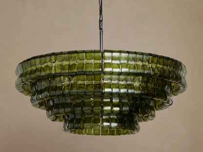 Ghiaccio Round Chandelier: multi-tiered, dark green curved glass with wavy edges, glowing warmly from internal lights.