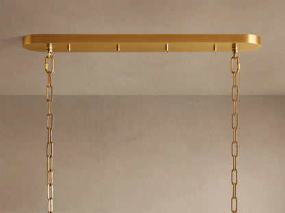 Close-up of Ghiaccio Oval Chandelier, showing rows of glowing, curved olive-green glass panels diffusing warm light.