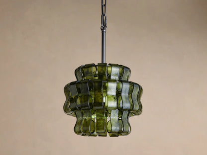 Ghiaccio Pendant: Dark green wavy curved glass pieces around a warm yellow glow, hanging from a black chain against a dark background.