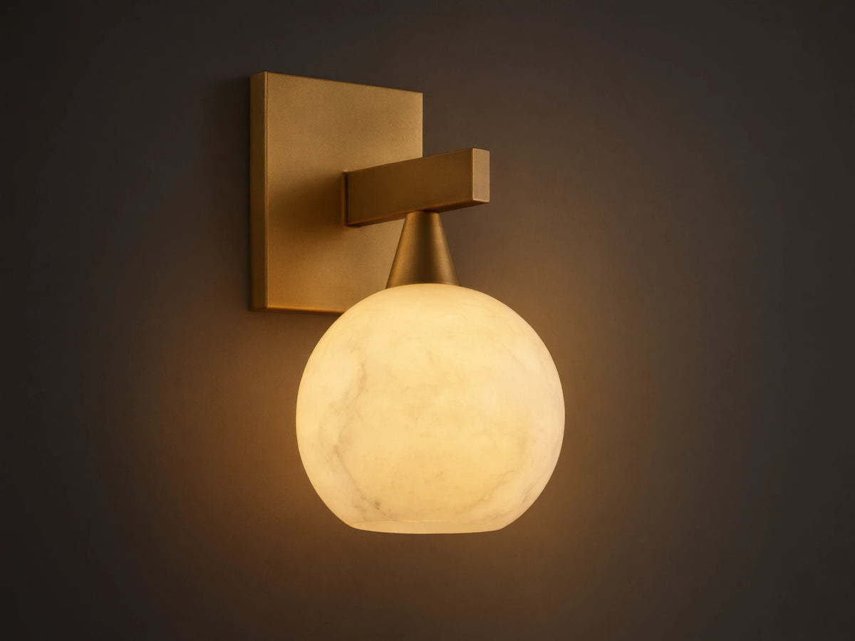 Front view of a brass wall light with a square backplate, horizontal arm, and glowing, translucent white veined globe shade.