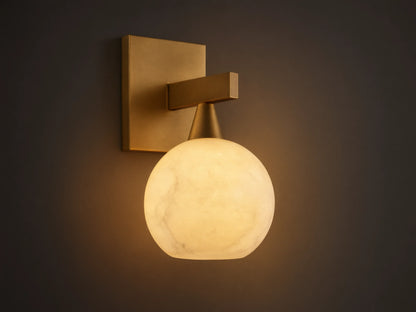 Front view of a brass wall light with a square backplate, horizontal arm, and glowing, translucent white veined globe shade.