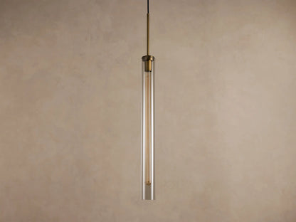 Brass and clear glass cylindrical pendant light with an exposed filament bulb, hanging vertically.