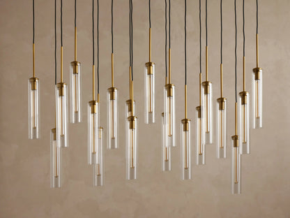 Underside view of a rectangular gold metal canopy with twenty black electrical cords hanging vertically from it.