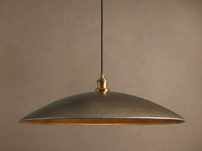 Recycled Metal Fan Pendant with wide, hammered brass-finished shade and reflective golden interior, hanging from a black cord.