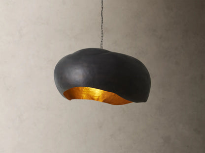 Front view of the black Fria Dome Pendant, an organically shaped light with a textured gold interior.