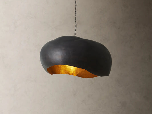 Front view of the black Fria Dome Pendant, an organically shaped light with a textured gold interior.