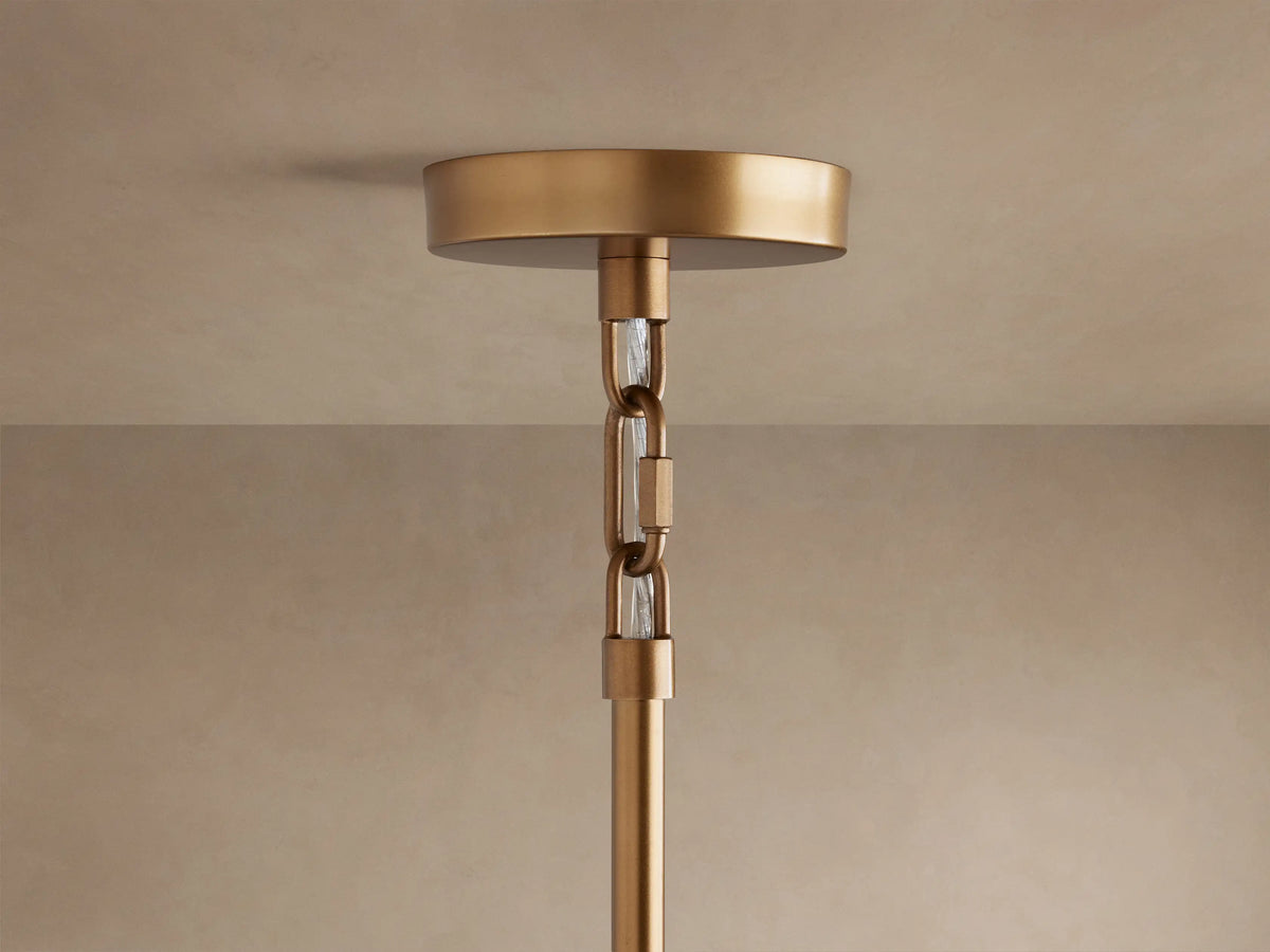 Close-up of Saige Round Chandelier's brass ceiling mount and part of its hanging rod with decorative clear accents.