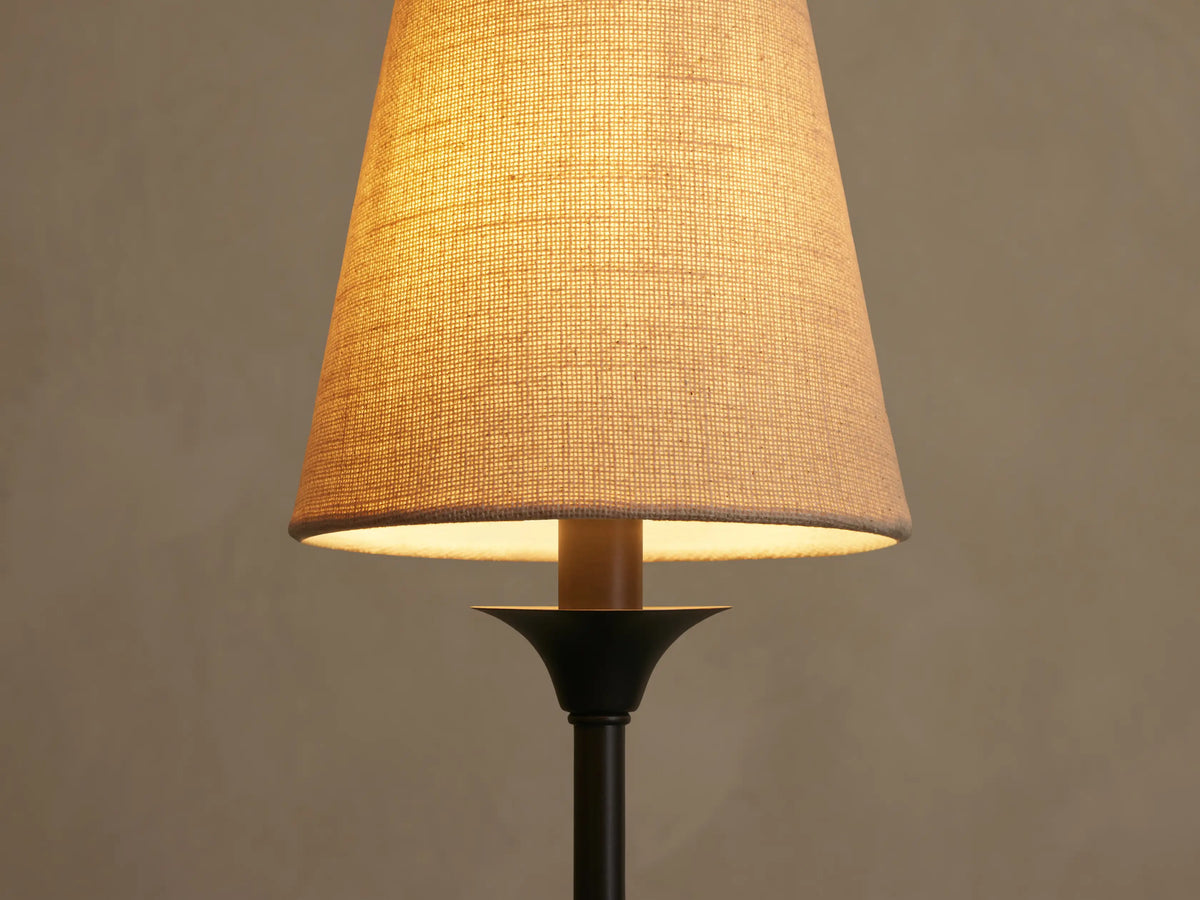Saige Round Chandelier close-up of an illuminated off-white textured fabric shade with a dark bronze metal arm.