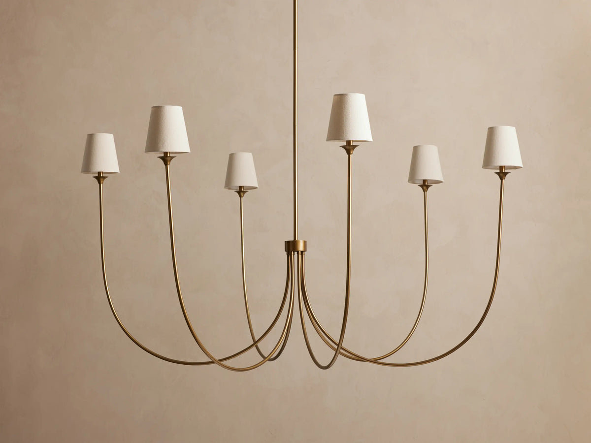Saige Round Chandelier: Brass finish, 6 gracefully curved arms, each with an off-white tapered fabric shade.