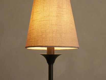 Saige Round Chandelier: Close-up of an illuminated, off-white textured shade over a dark bronze metal component.