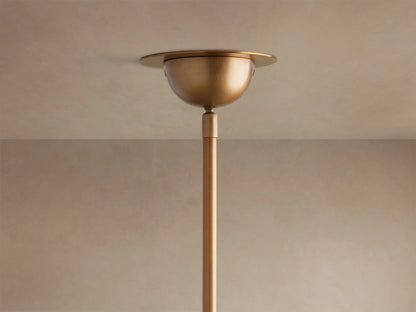 Saguaro Chandelier close-up shows three glowing, bowl-shaped alabaster shades on antique brass arms against a neutral background.