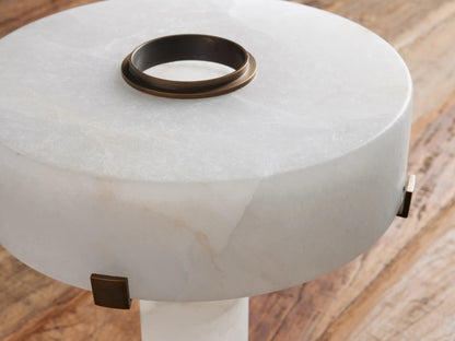 Close-up of Chayla Table Lamp's round white alabaster top with antique brass ring & small metallic side accents on wood.