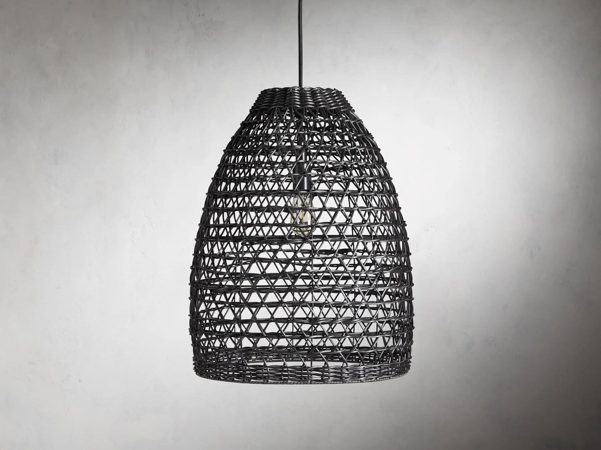 Braemar Outdoor Black Pendant with a woven all-weather wicker shade, hanging from a black fabric-wrapped cord, bulb visible within.