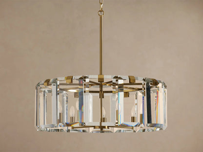 Amaya Round Chandelier, featuring a round, faceted clear crystal drum with a brass-plated frame, unlit candelabra bulbs inside.