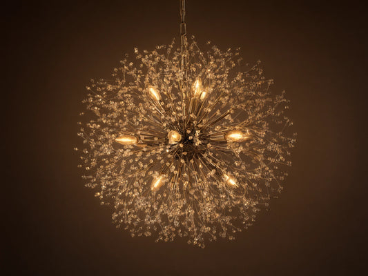 Dandelion Round Chandelier, nickel-plated with many thin arms radiating out, adorned with clear glass crystals and warm lit bulbs.