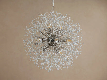 Dandelion Round Chandelier, nickel-plated with many thin arms radiating out, adorned with clear glass crystals and warm lit bulbs.