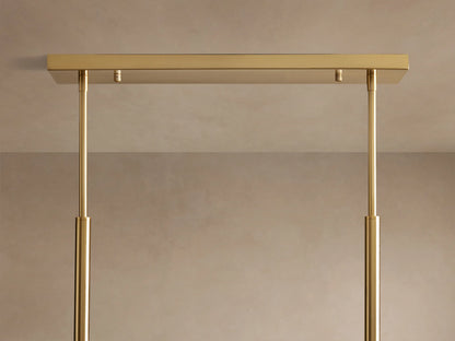 Roscoe Linear Chandelier: Close-up of clear glass globes with illuminated LED bulbs, hanging from brass rods.