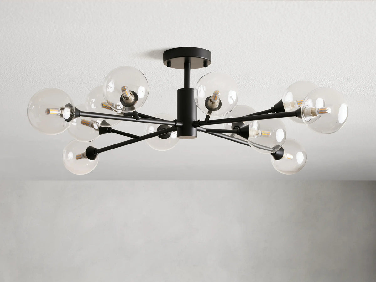 Apollo Flush Mount with an antiqued bronze finish, features multiple clear glass globes extending from a central fixture, mounted on a ceiling.