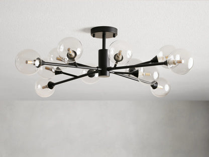 Apollo Flush Mount with an antiqued bronze finish, features multiple clear glass globes extending from a central fixture, mounted on a ceiling.