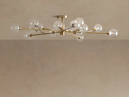 Apollo Flush Mount: A modern gold flush mount ceiling light with radiating brass arms and multiple illuminated clear glass globe bulbs.