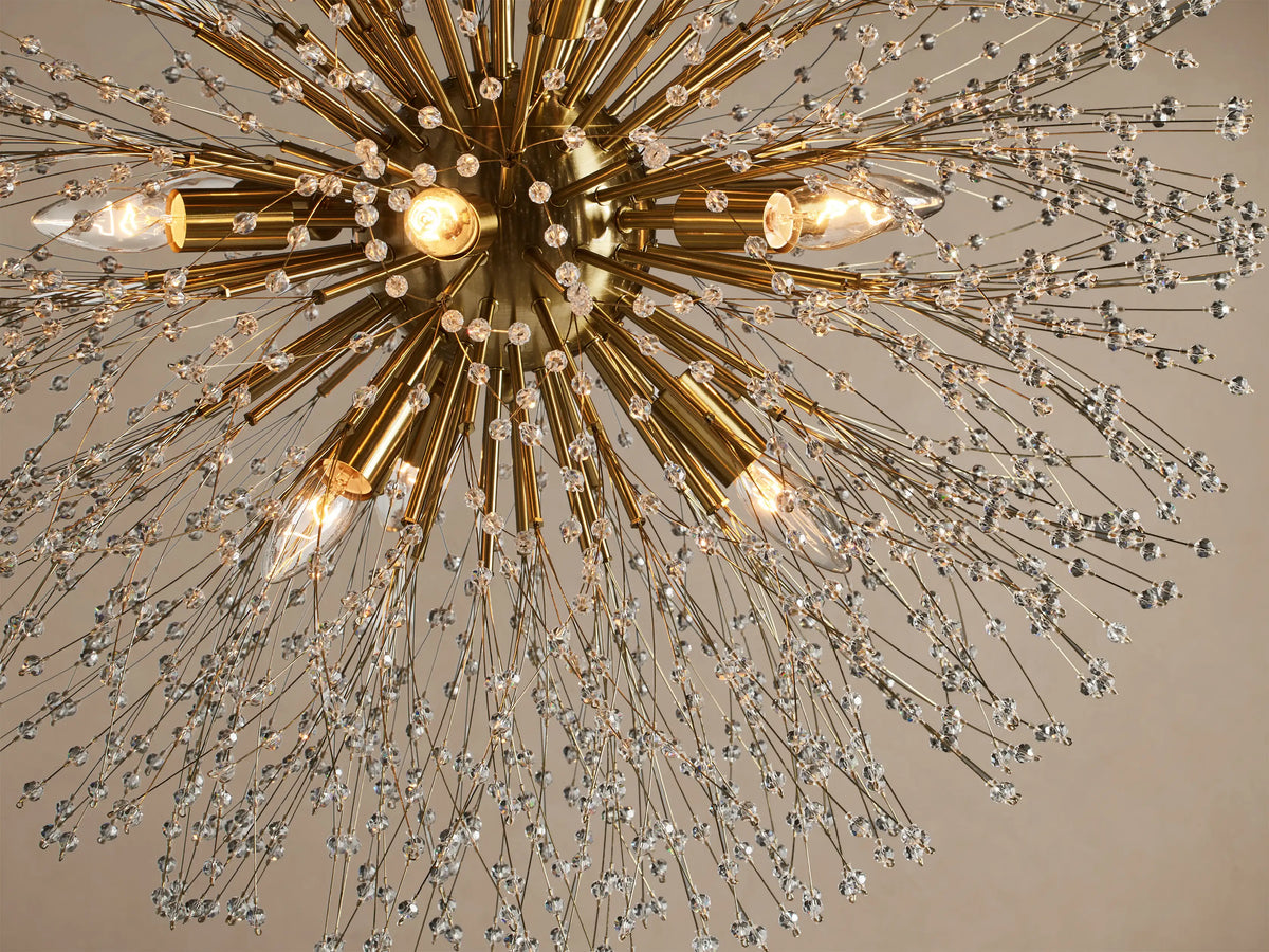 Round Dandelion Chandelier with a gold core, radiating nickel arms tipped with sparkling clear crystals, hanging from above.