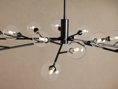 Apollo Round Chandelier: 18 clear globe bulbs on black metal arms radiate from a central stem, against a beige wall.