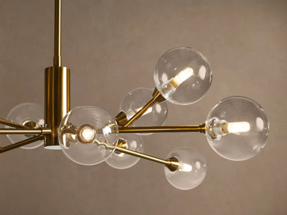 Apollo Round Chandelier with a central rod, plated brass frame, clear glass globe shades, and visible LED bulbs, suspended.