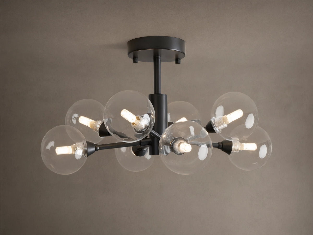 Apollo Flush Mount, dark metal, with eight clear spherical bulbs glowing. Mounted on a light brown ceiling.