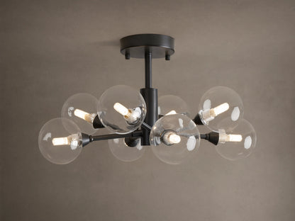 Apollo Flush Mount, dark metal, with eight clear spherical bulbs glowing. Mounted on a light brown ceiling.
