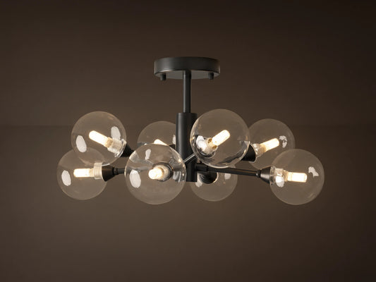 Apollo Flush Mount, dark metal, with eight clear spherical bulbs glowing. Mounted on a light brown ceiling.