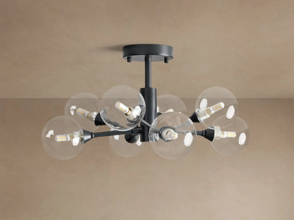 Apollo Flush Mount, dark metal, with eight clear spherical bulbs glowing. Mounted on a light brown ceiling.
