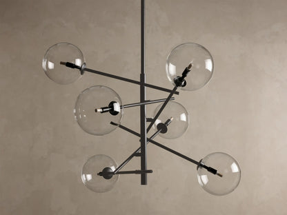 Front view of the bronze Roscoe Chandelier with six clear glass globes extending from a dark, angular central frame. Bulbs are illuminated.