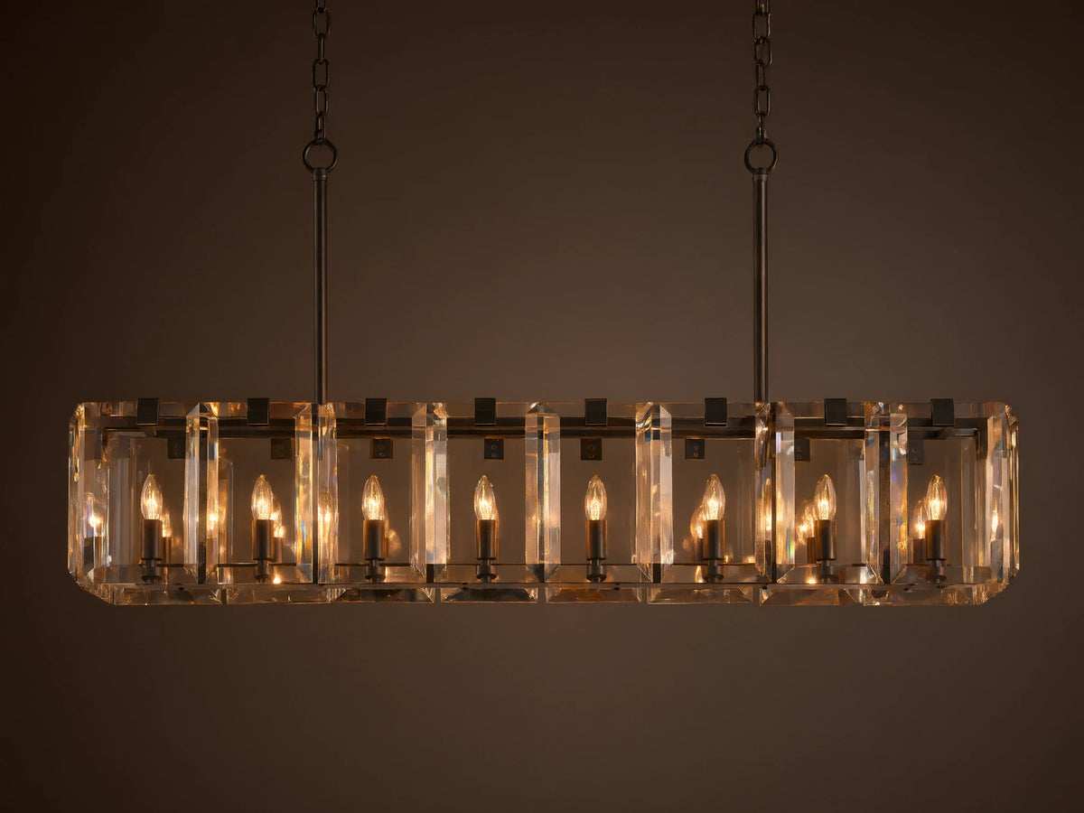 Rectangular chandelier with clear crystal panels and black iron frame, featuring twelve lit candle-style bulbs, hanging from chains.