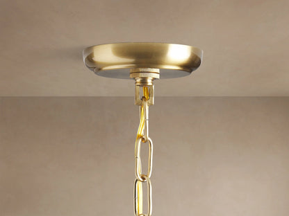 Close-up of Lily Round Chandelier. Clear glass petals and golden rods radiate from a central brass sphere with small bulbs.