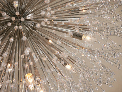 Silver Dandelion Round Chandelier hanging, featuring radiating nickel-plated arms adorned with numerous clear glass crystals.