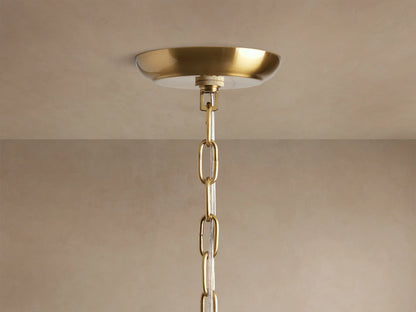 Close-up gold Dandelion Chandelier, radiating spokes adorned with sparkling clear glass crystals and warm glowing bulbs.