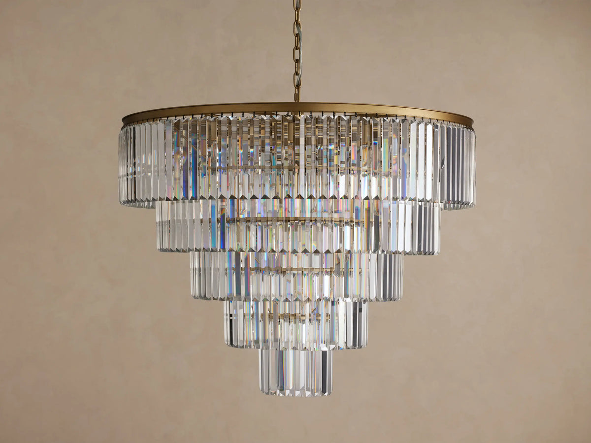 Leyland Tiered Round Chandelier, with multiple layers of rectangular clear K9 crystals glowing warmly, hanging from a dark bronze frame.