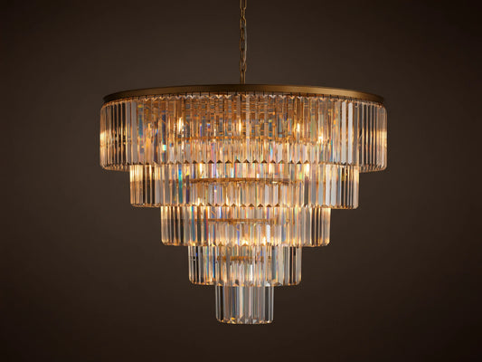 Leyland Tiered Round Chandelier, with multiple layers of rectangular clear K9 crystals glowing warmly, hanging from a dark bronze frame.