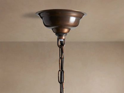Laila Pendant: cylindrical light with vertical antiqued mirrored-glass panes in an antique copper frame, glowing warmly from within.