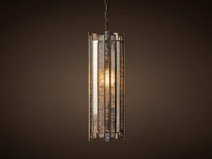 Laila Pendant, a cylindrical light with vertical antiqued mirrored-glass panels and an antique copper frame, glowing warmly.